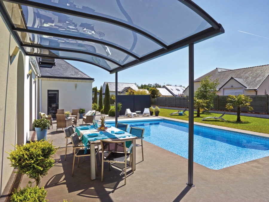 Abri de terrasse vitré courbe AFC à structure noire au bord de piscine, maison Caen.