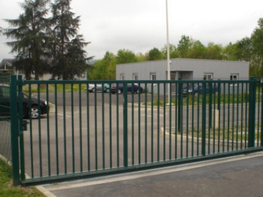 Portail coulissant acier vert AFC barreauté, accès parking entreprise Calvados.