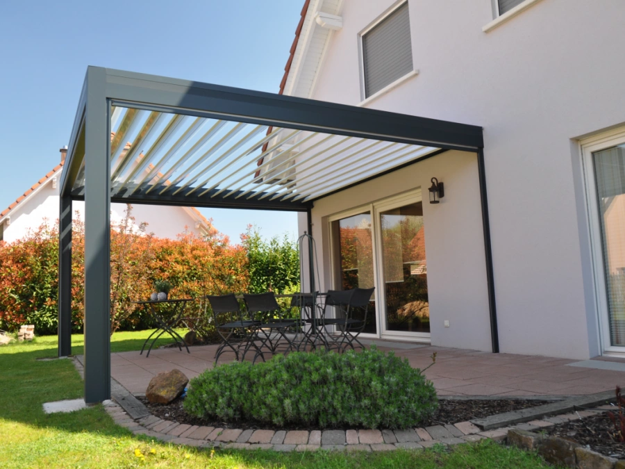 Pergola bioclimatique anthracite AFC à lames blanches sur terrasse, jardin Calvados.