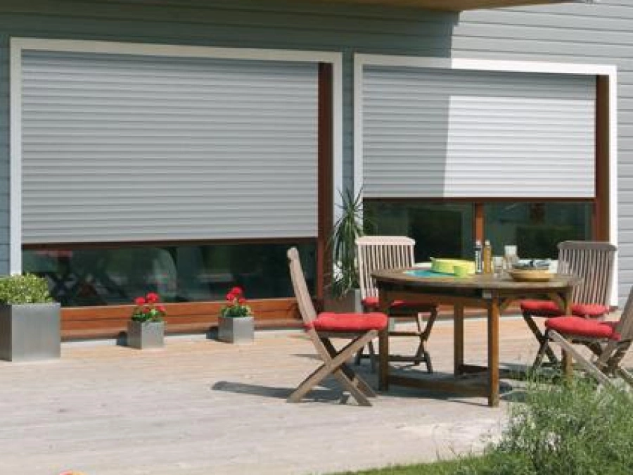 Volets roulants gris clair AFC sur baies bois, terrasse repas ensoleillée Calvados.