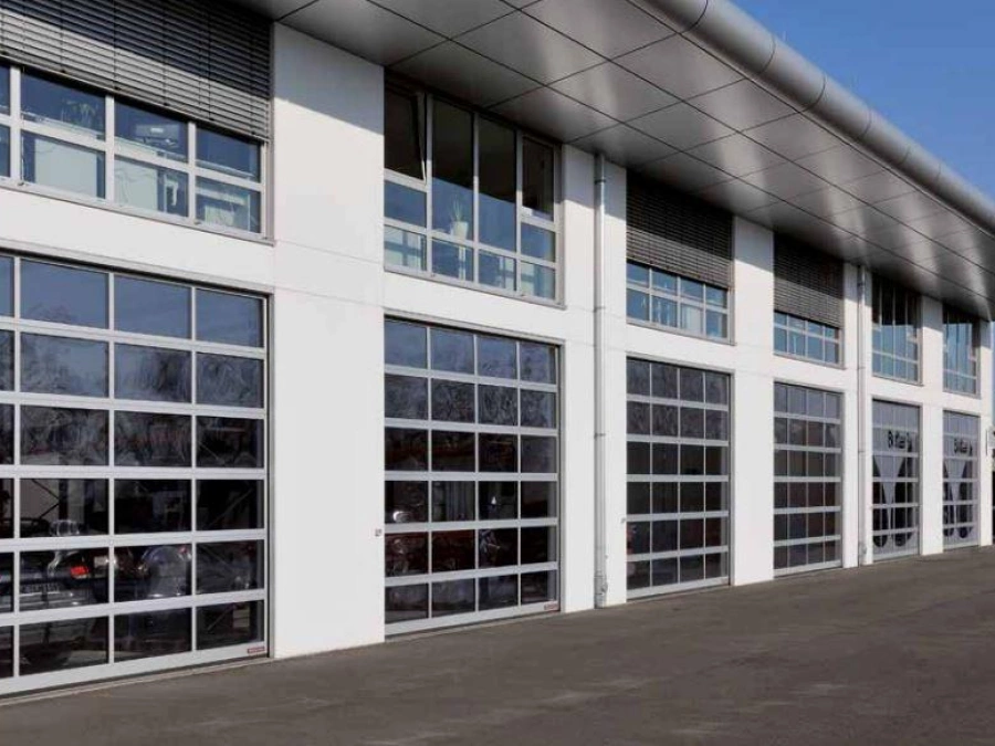 Portes de garage industrielles vitrées AFC en façade blanche, site pro près de Caen.