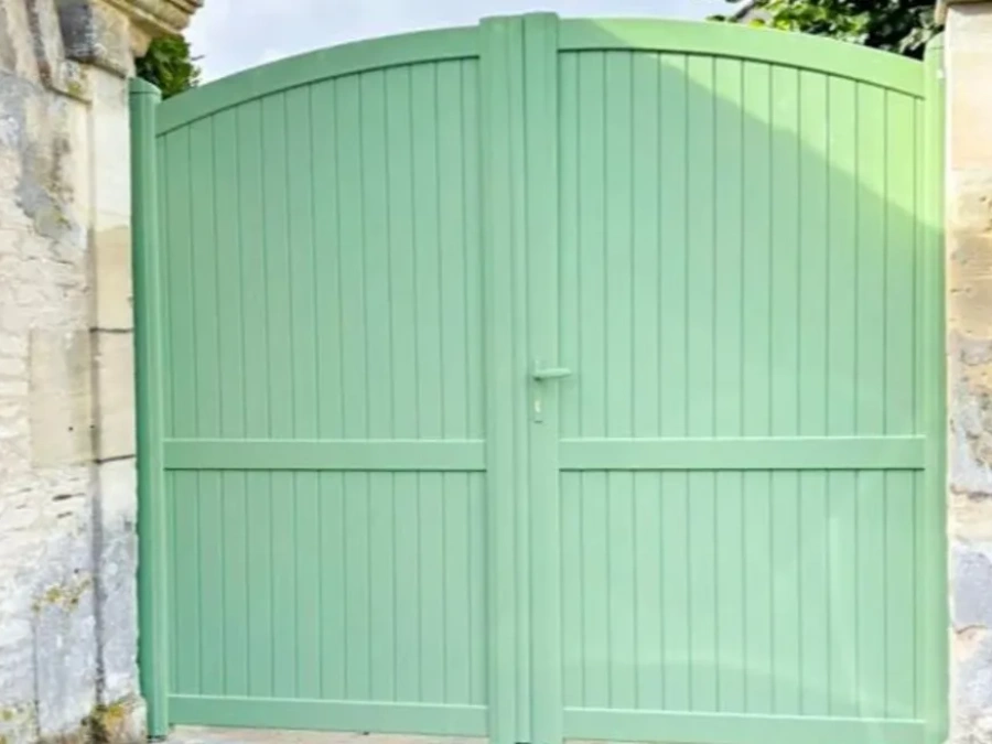 Portail aluminium contemporain XL SIB vert amande, forme bombée entre piliers pierre de Caen