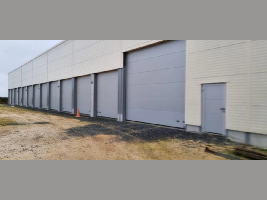 Rangée de portes sectionnelles grises Hormann pour box professionnels, installation AFC dans le Calvados