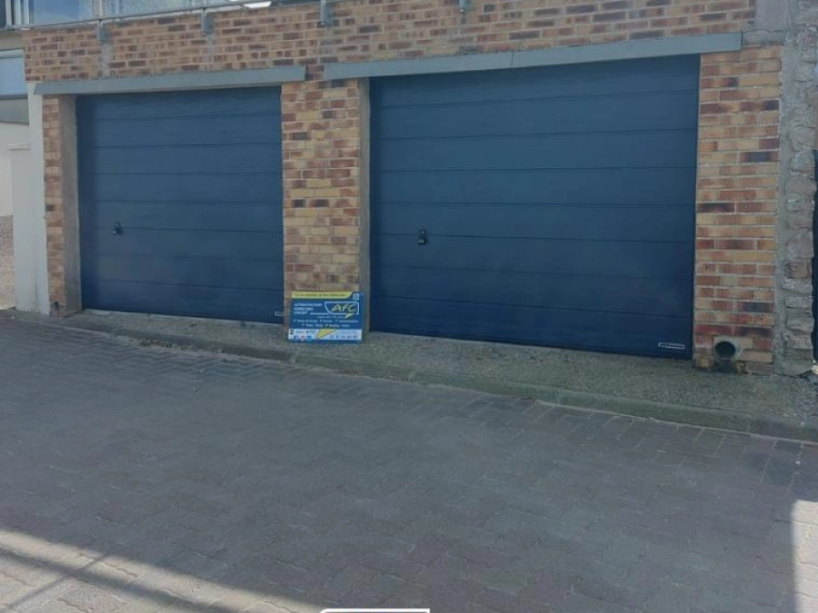 Deux portes de garage sectionnelles anthracite sur façade brique, devanture maison Calvados par AFC