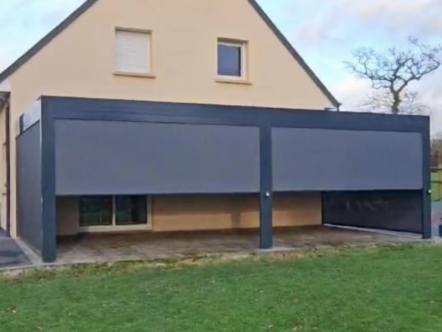 Pergola bioclimatique aluminium anthracite avec stores verticaux motorisés sur terrasse, maison individuelle AFC Caen.