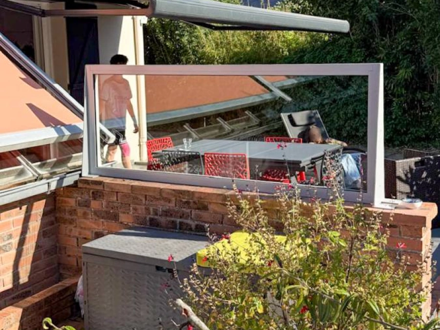 Châssis vitré fixe sur muret de brique et store banne terracotta, terrasse aménagée par AFC