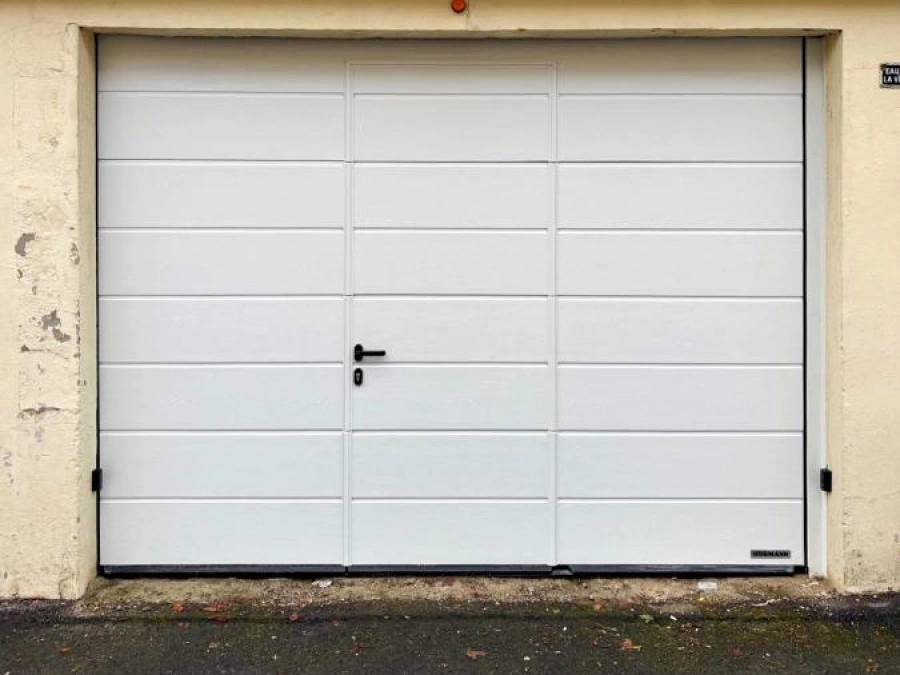 Porte de garage sectionnelle blanche Hörmann avec portillon intégré, façade pierre, AFC Caen