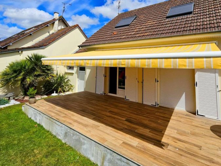 Store banne motorisé à rayures jaune et blanc déployé sur terrasse, maison Calvados par AFC
