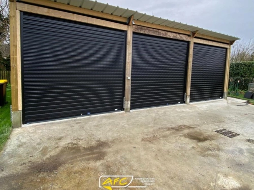 Trois rideaux métalliques noirs sur hangar bois, garage à bateaux Calvados, pose AFC