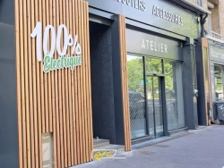 Façade de magasin avec vitrine aluminium anthracite et habillage bois vertical, atelier scooters, réalisation AFC Caen.