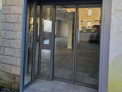 Nouvelle entrée de pharmacie en aluminium anthracite et verre, baie fixe en imposte, réhabilitation AFC Caen.
