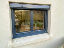 Fenêtre anthracite avec coffre de volet roulant intégré sur façade crème, menuiserie posée par AFC près de Caen.