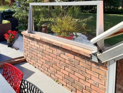 Châssis fixe aluminium et verre sur mur de brique, vue jardin depuis terrasse, pose AFC