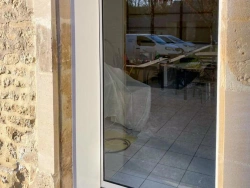 Menuiserie vitrée aluminium blanche encastrée dans façade pierre, rénovation Calvados AFC