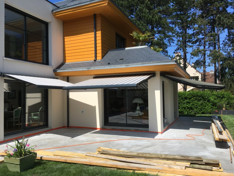 Stores bannes rayés gris et blanc déployés sur terrasse de maison contemporaine, AFC Calvados