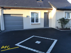 Ensemble porte de garage et porte d'entrée grises sur façade claire, réalisation AFC Calvados