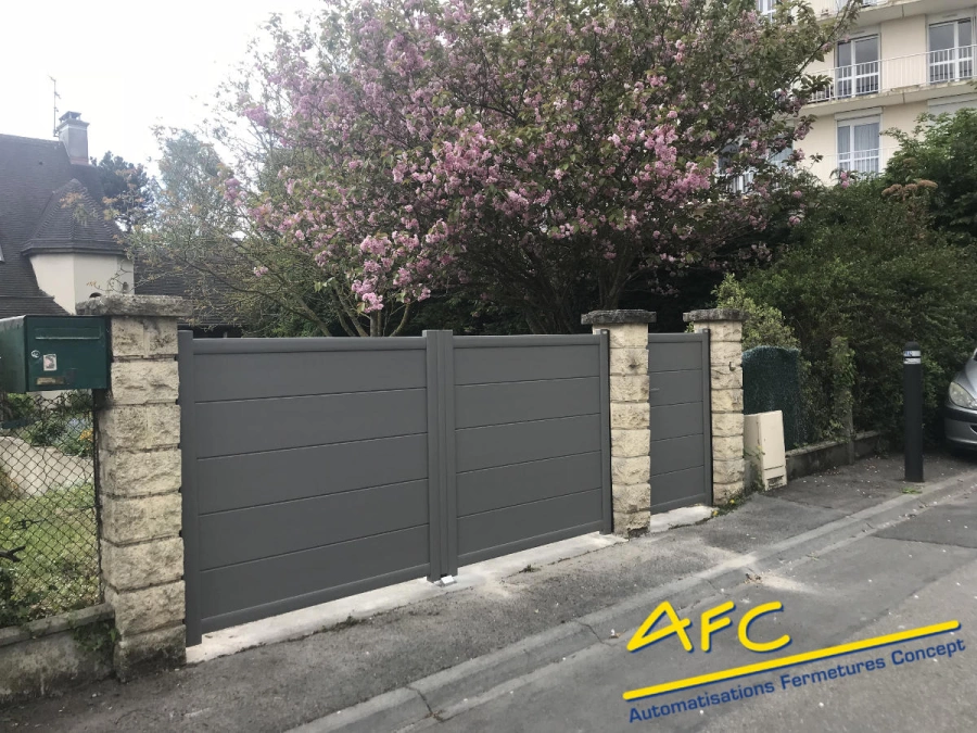 Portail aluminium anthracite motorisé et portillon assorti entre piliers pierre, entrée AFC Caen