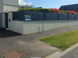 Clôture aluminium gris anthracite sur muret d'angle, aménagement extérieur résidentiel Normandie