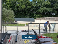 Pose d'une barrière de sécurité verre et aluminium noir autour d'une piscine couverte, chantier AFC Calvados.